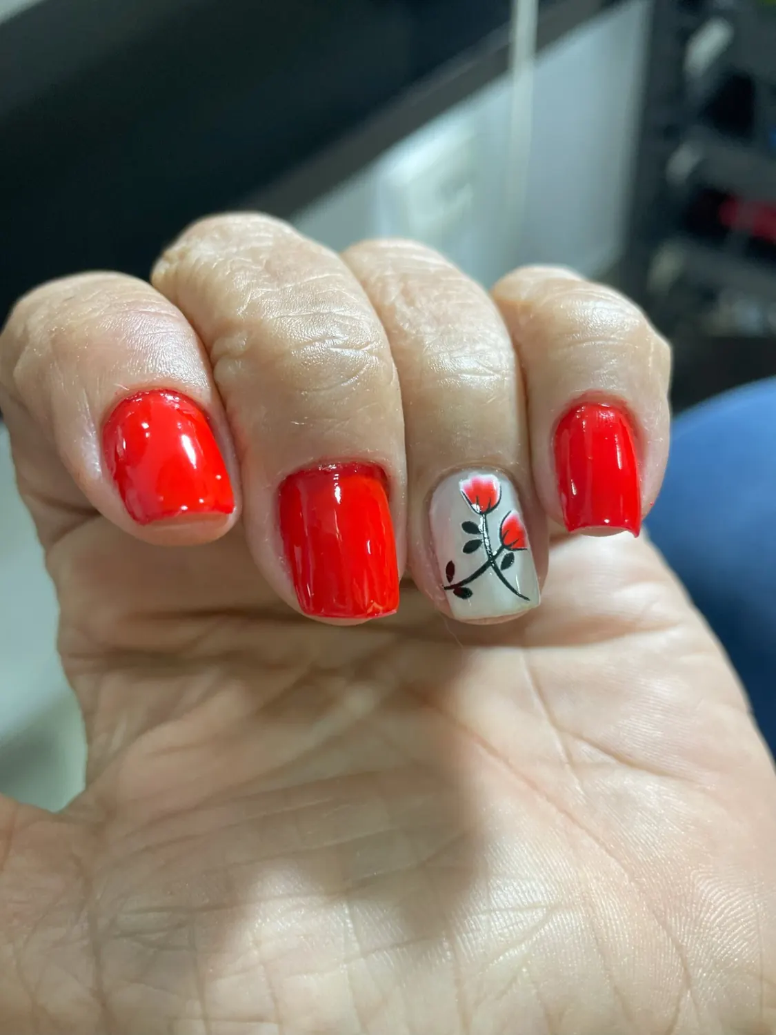 Unhas vermelhas com nail art floral